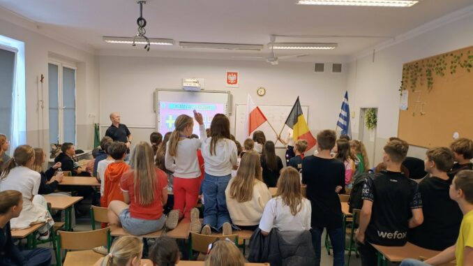grupa uczniów w klasie_w tle flagi