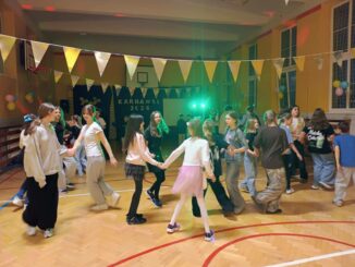 dzieci tańczą w sali gimnastycznej przystrojonej karnawałowo