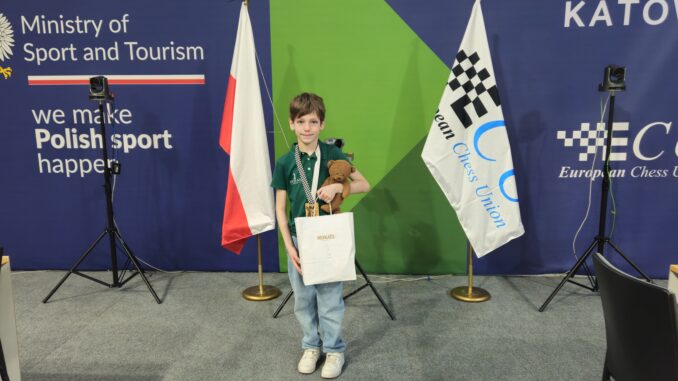 Uczeń stoi z nagrodami za turniej szachowy