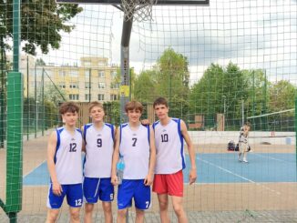 pięciu chłopców w strojach sportowych ba boisku do koszykówki