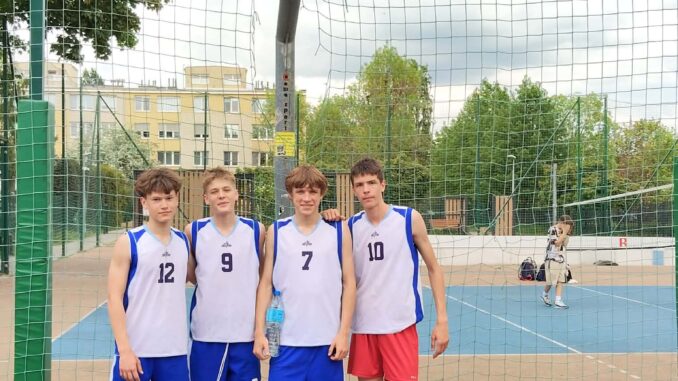 pięciu chłopców w strojach sportowych ba boisku do koszykówki